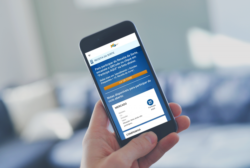 Pessoa segura um smartphone exibindo a tela do aplicativo Nota Fiscal Gaúcha, na seção 